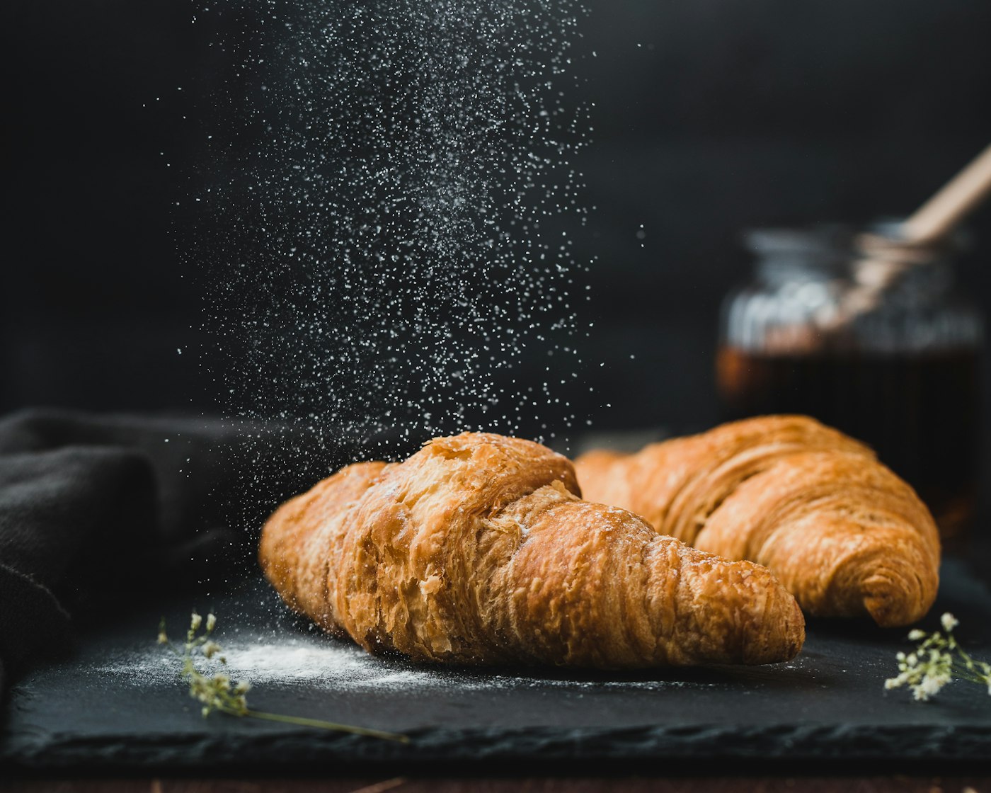 Golden artisan croissants dusted with powdered sugar