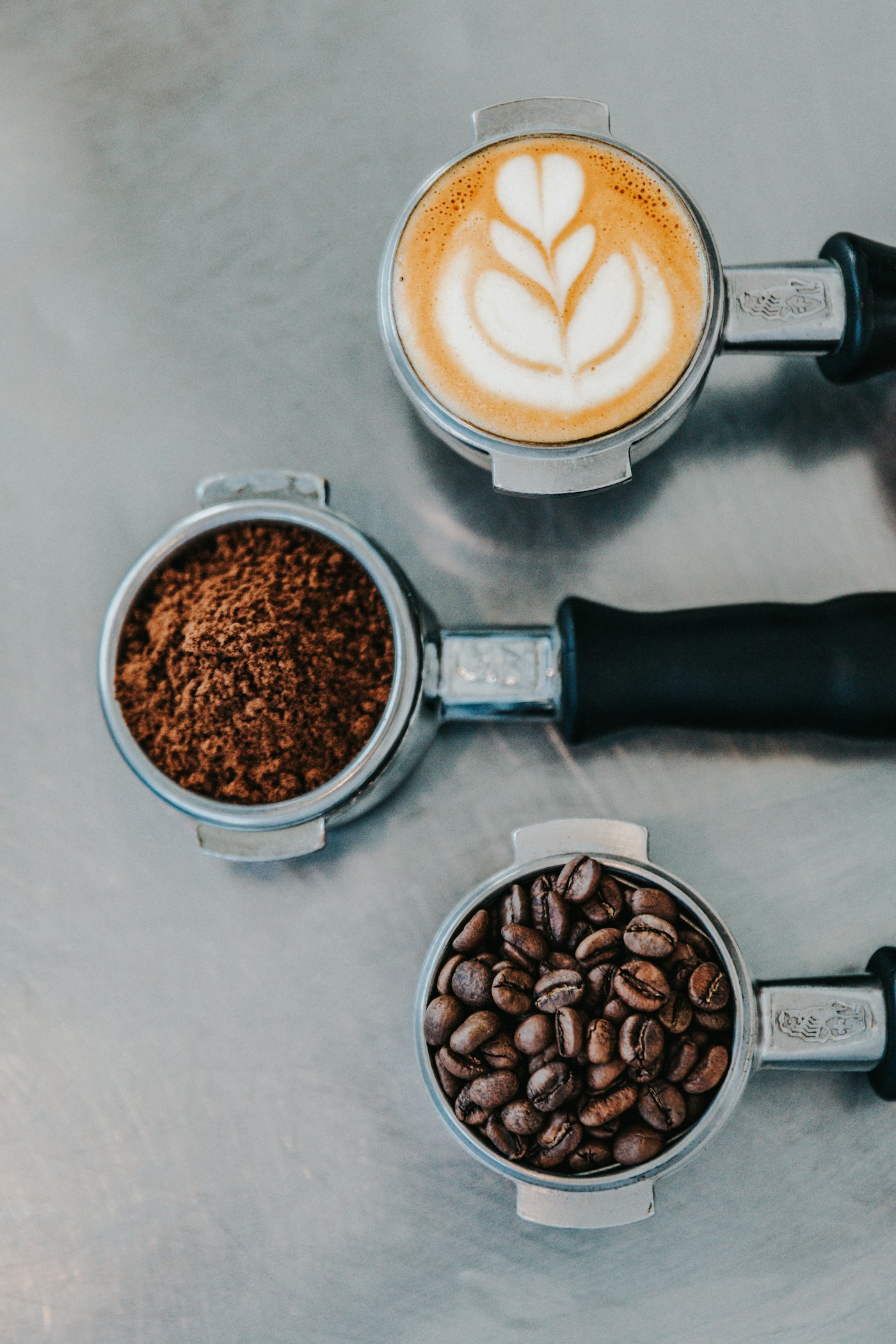 Artisanal espresso portafilters with ground coffee and latte art
