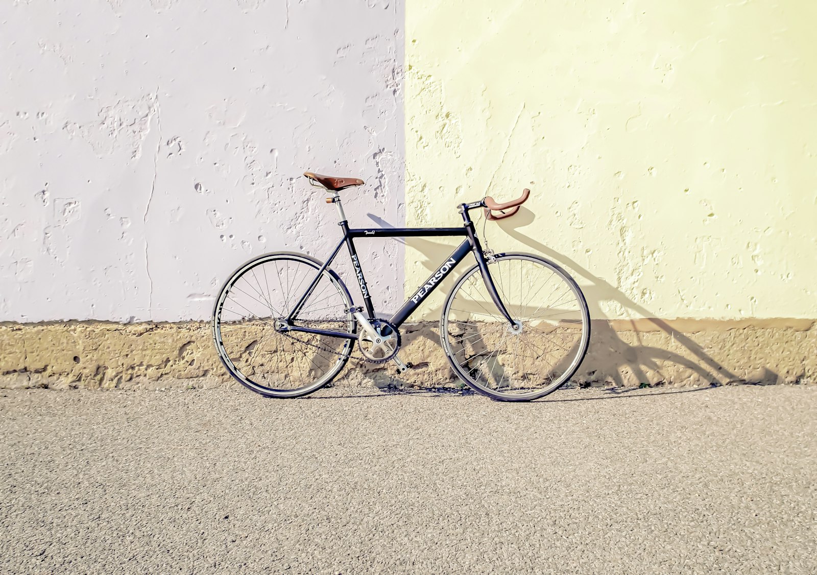 Outdoor bicycle leaning against clean wall