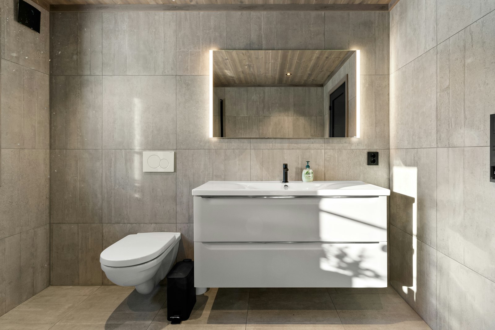 Clean modern tiled bathroom vanity and mirror installation